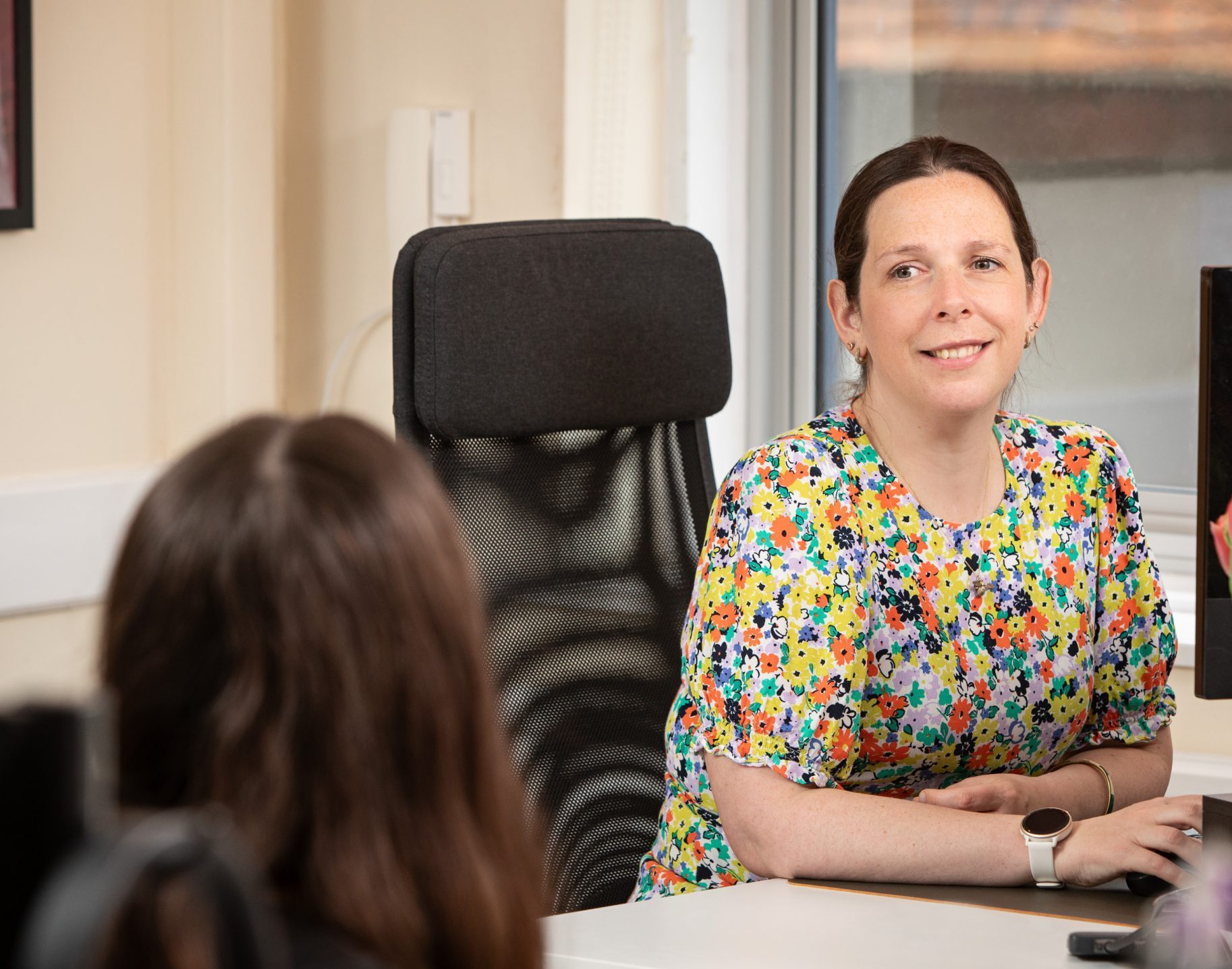 team manager smiling at her desk
